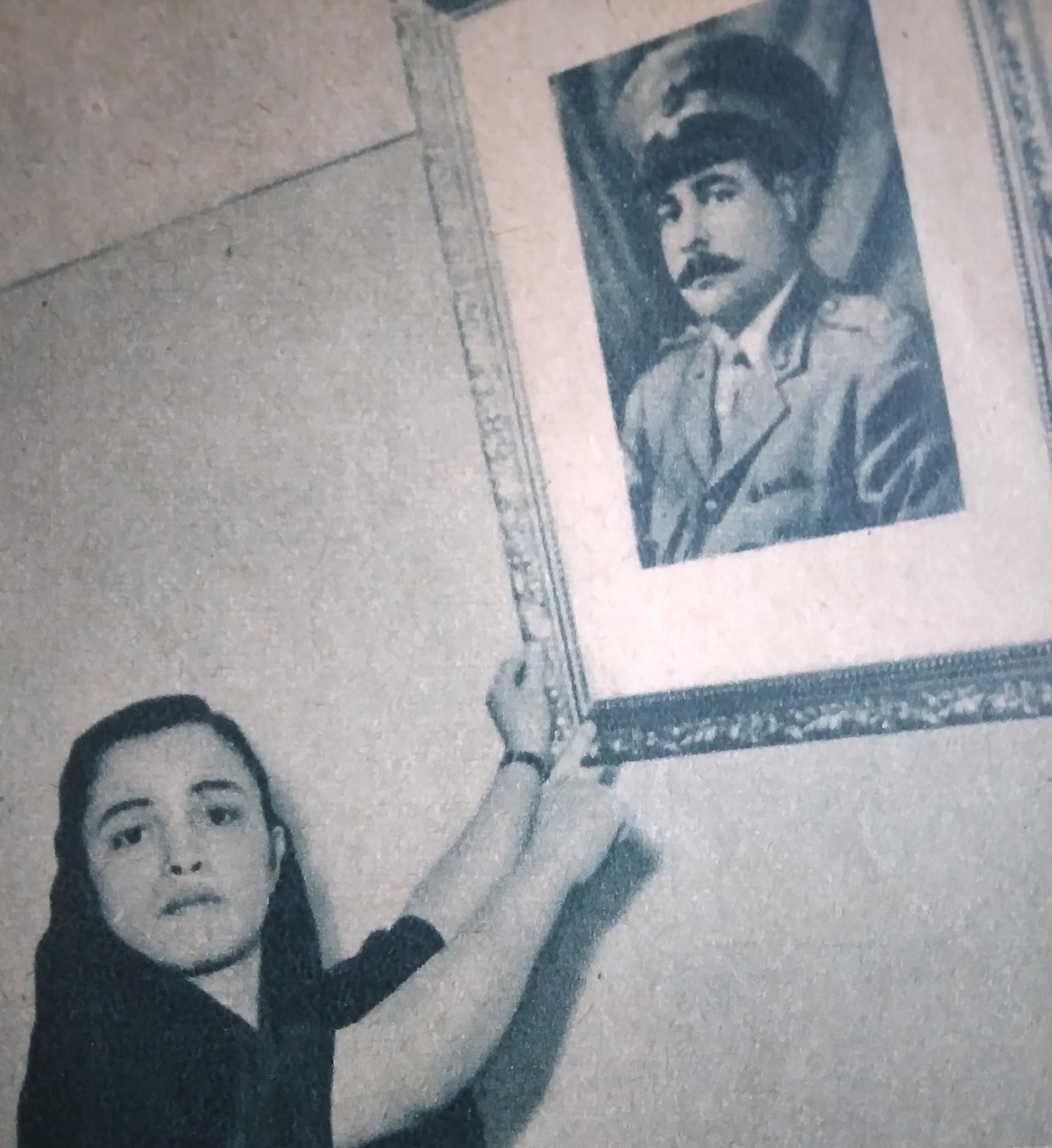 زوجة الشهيد عبدالقادر طه مع صورته